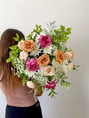 A bunch of rustic style flowers with brown and nude roses