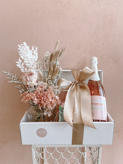 Gift basket with alcohol, candle and dried jar of flowers